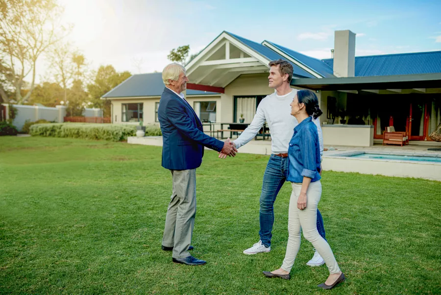 Agent shaking hands with new home owners
